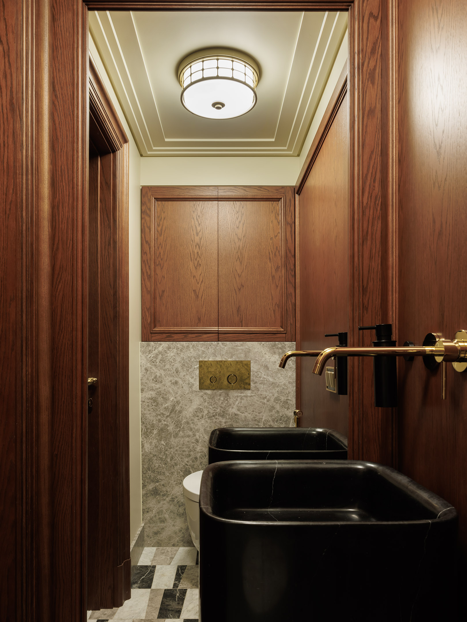 Раковина из мрамора Nero Marquina дополнена смесителями итальянского бренда NewForm. Унитаз с округлыми формами из коллаборации дизайнера Клаудио Сильвестрина и бренда Cielo.